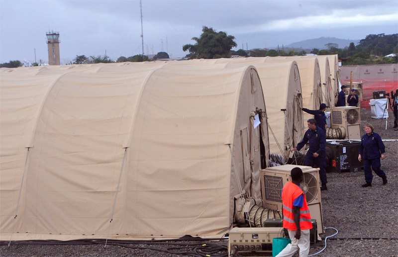 In this photo taken Wednesday Nov. 5, 2014, on the outskirts of the city of Monrovia, Liberia, health workers walk around medical tents that form part of a new American clinic to be used for the treatment of people suffering from the Ebola virus. As the Ebola epidemic flares in new hot spots and dims in others, the response to its shifts must catch up, experts say, and that&rsquo;s a challenge because it is a slow process for governments to authorize aid, to gather it together and then deliver it. And to build treatment units, even rudimentary ones, takes even more time. By the time it&rsquo;s built, the outbreak may have moved elsewhere. (AP Photo/Abbas Dulleh)