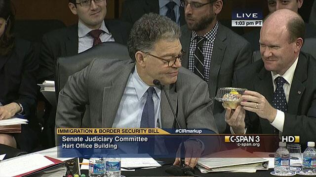 Senator Coons gives Senator Franken a birthday cupcake in the Judiciary Committee