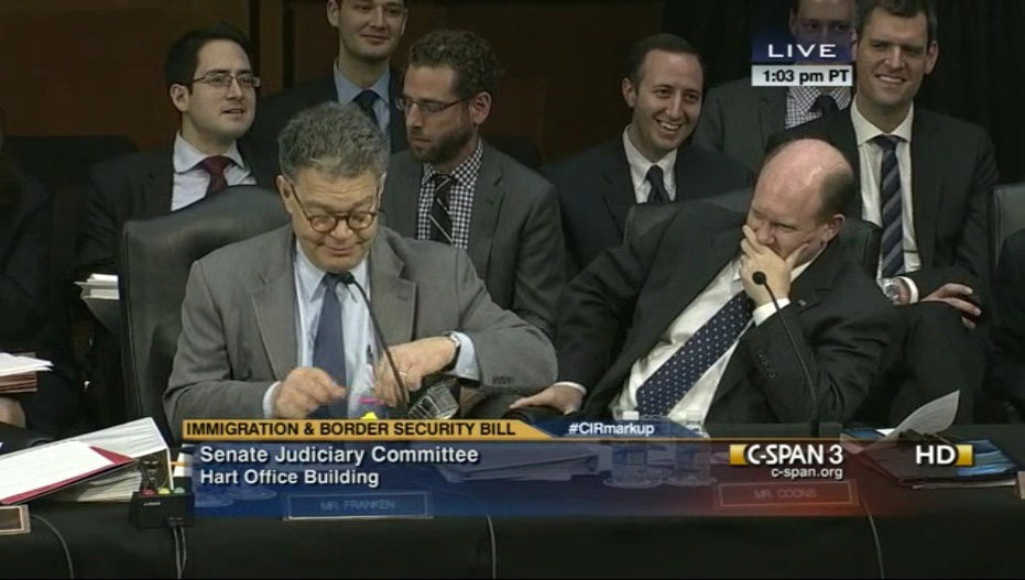Senator Coons gives Senator Franken a birthday cupcake in the Judiciary Committee